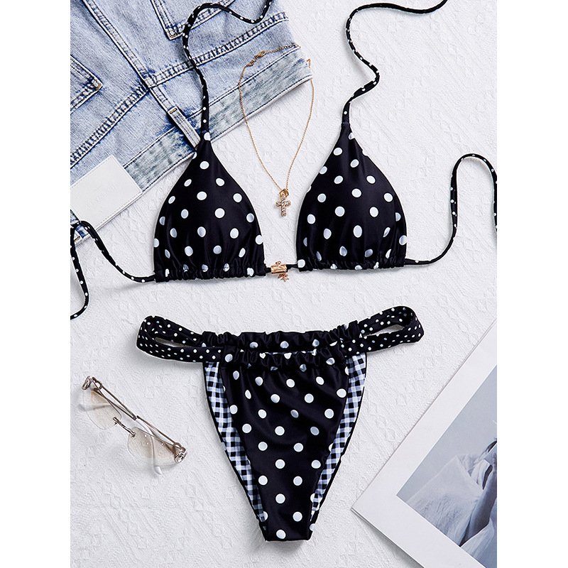 Black and white polka dot reversible triangle string bikini set with halter top and side tie bottoms.