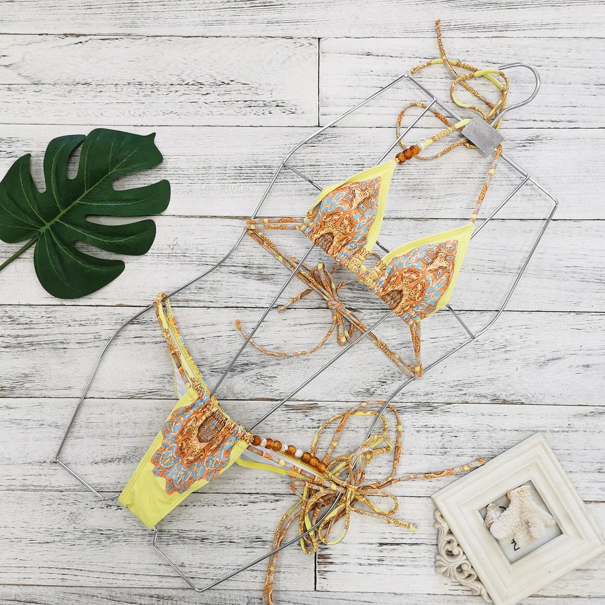 Yellow and blue patterned beaded string triangle bikini set with halter top and side-tie bottoms.
