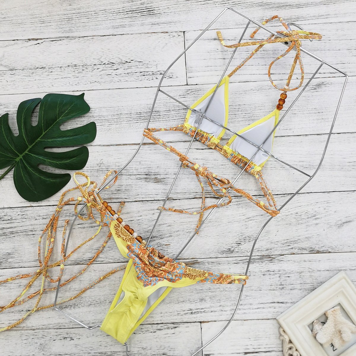 Yellow and patterned beaded string triangle bikini set with halter top and side-tie bottoms.