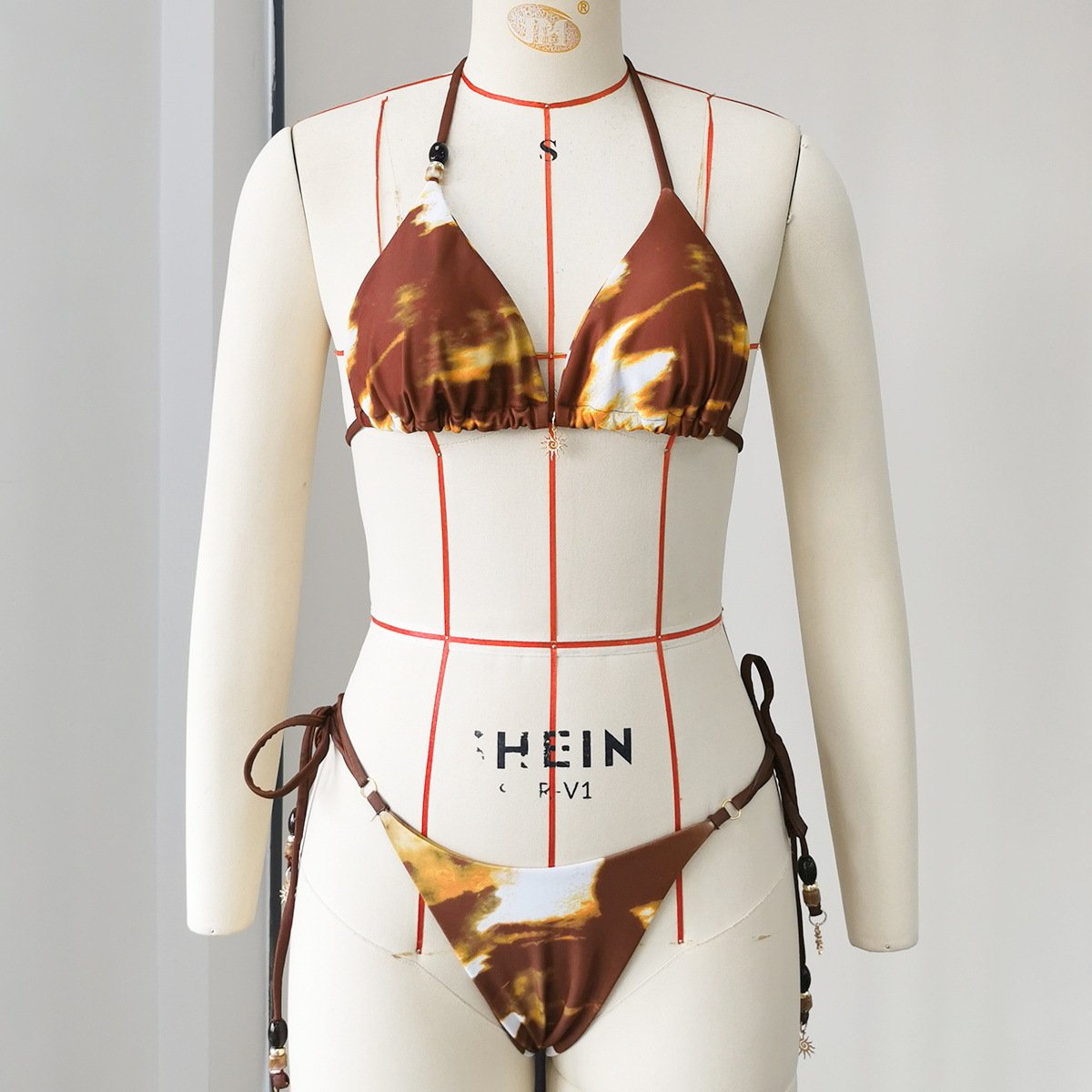 Brown and white tie-dye triangle bikini set with beaded halter straps and high-cut side ties.