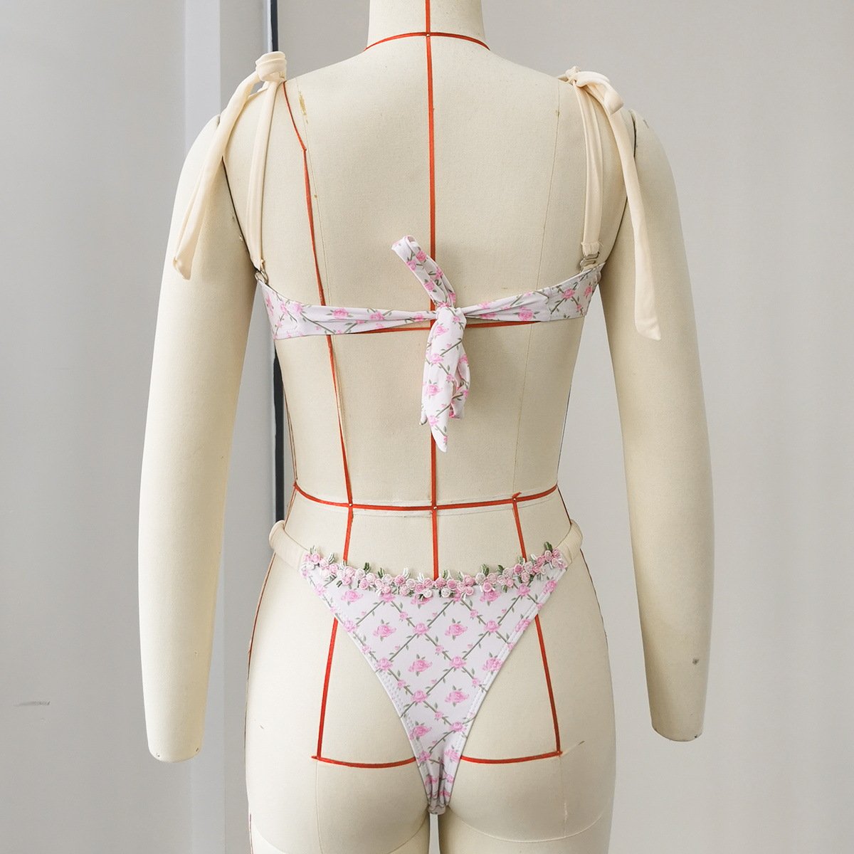 Back view of a white floral print bikini set featuring tie-shoulder straps, a back tie closure, and floral