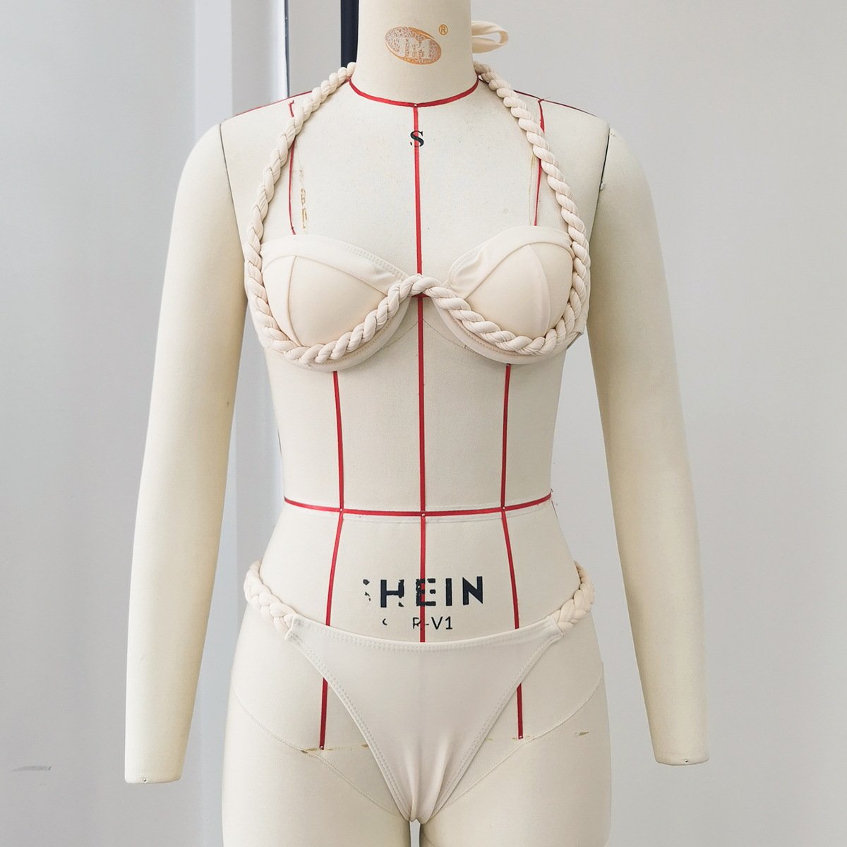 Cream two-piece bikini set featuring an underwire halter top and matching bottoms with thick braided rope trim detailing.