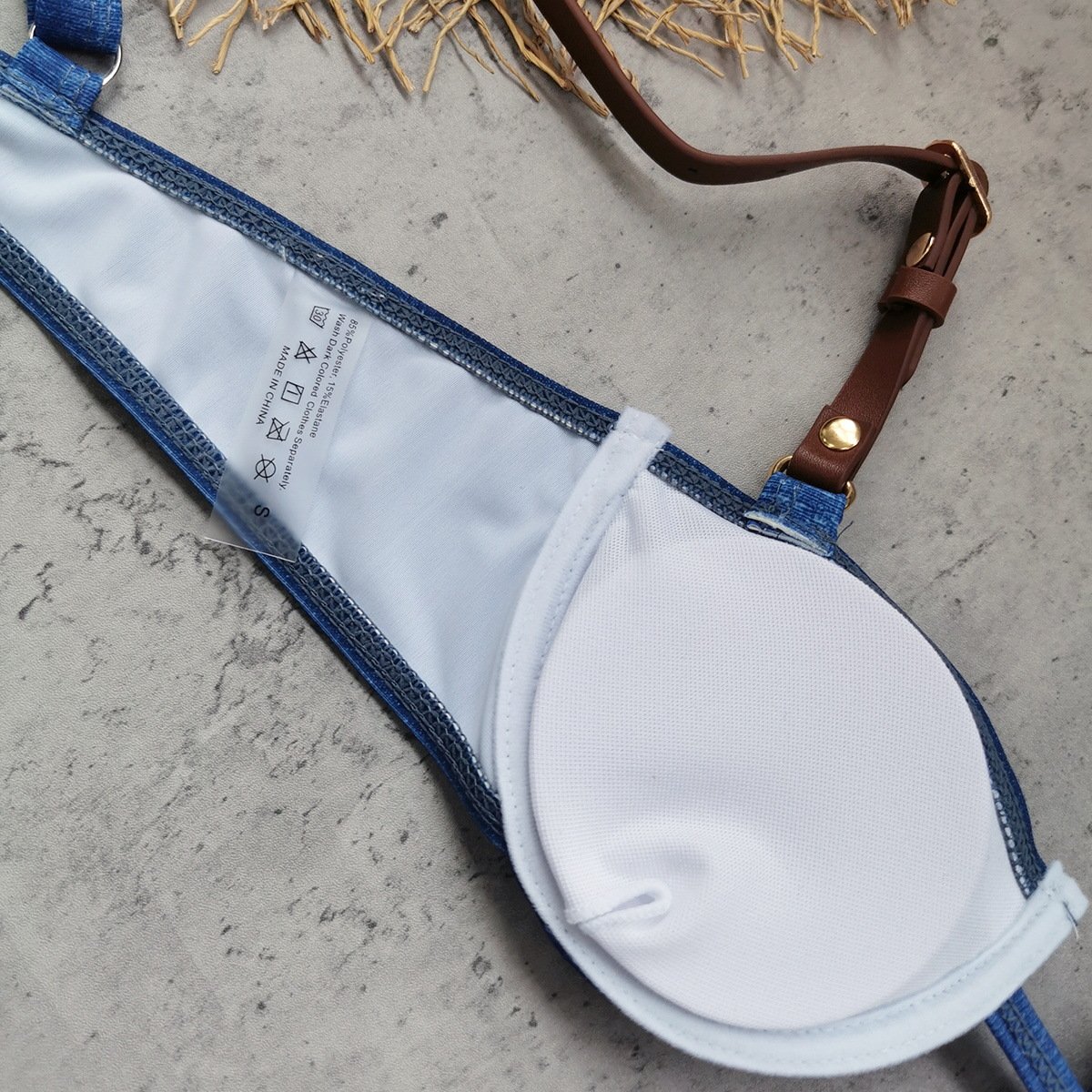 White molded cup bikini top with denim trim and adjustable brown leather buckle straps.