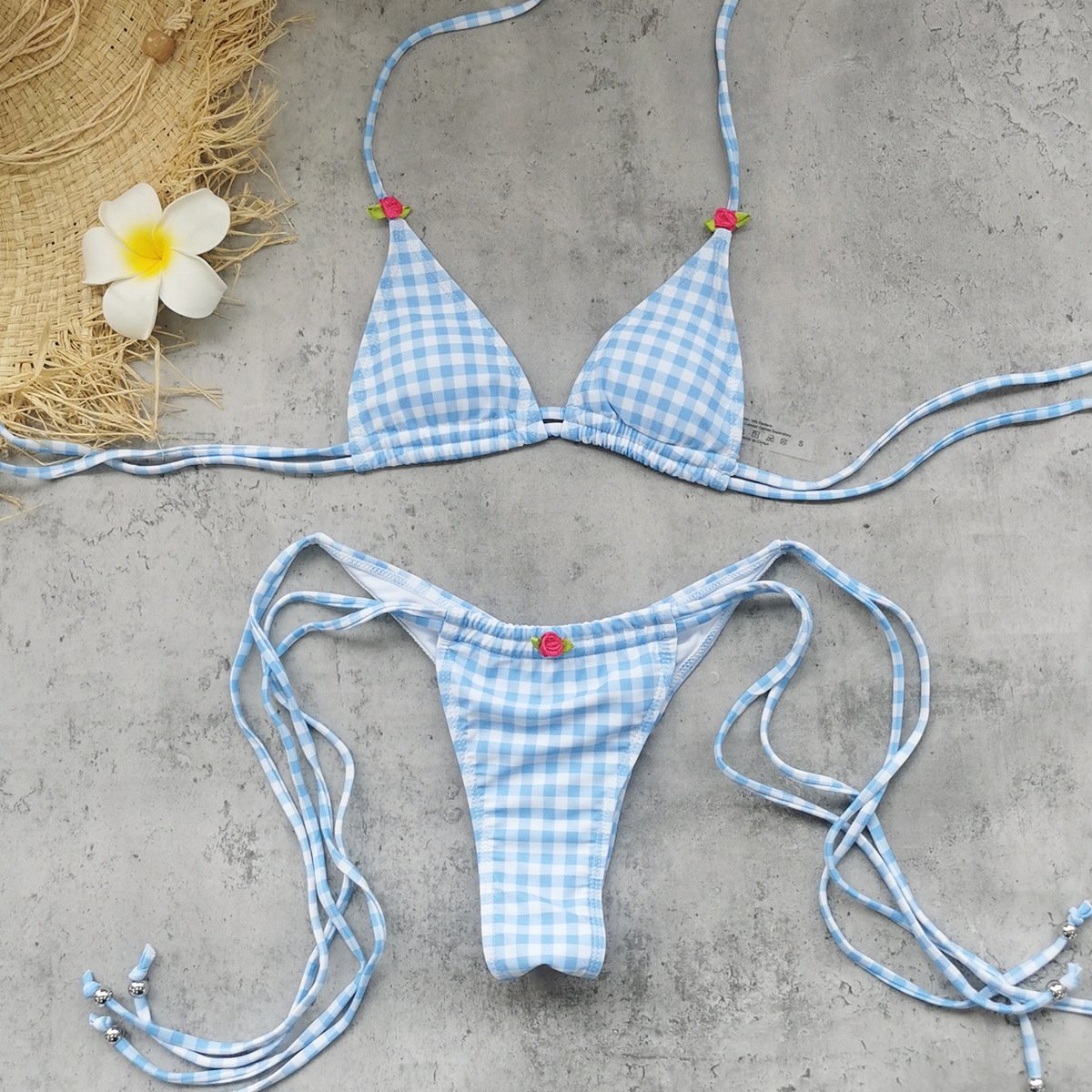 Blue and white gingham triangle bikini set with tie-side bottoms and small floral details.