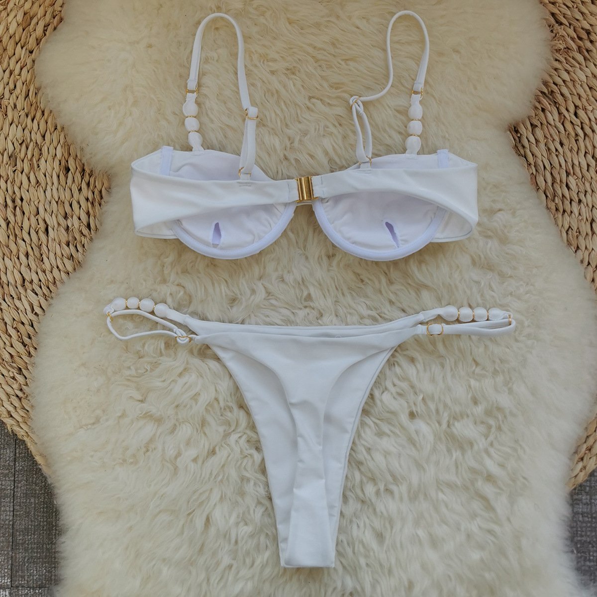 White two-piece bikini set featuring an underwire top with a gold front clasp and beaded adjustable straps.