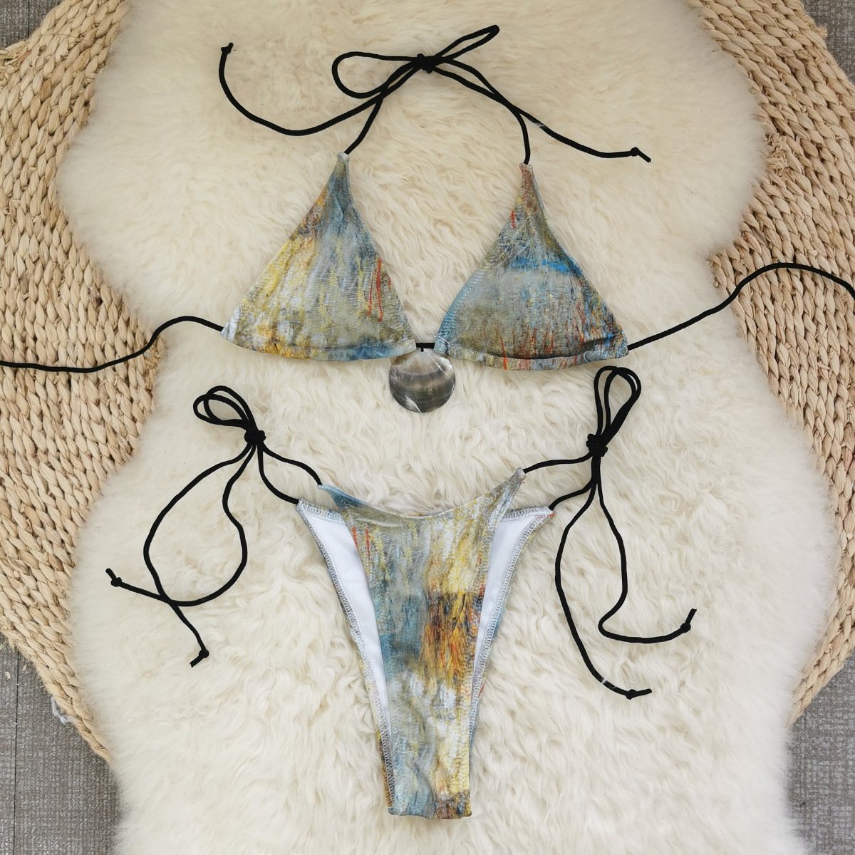 Abstract print triangle bikini set with halter straps, side ties, and a center pendant detail.
