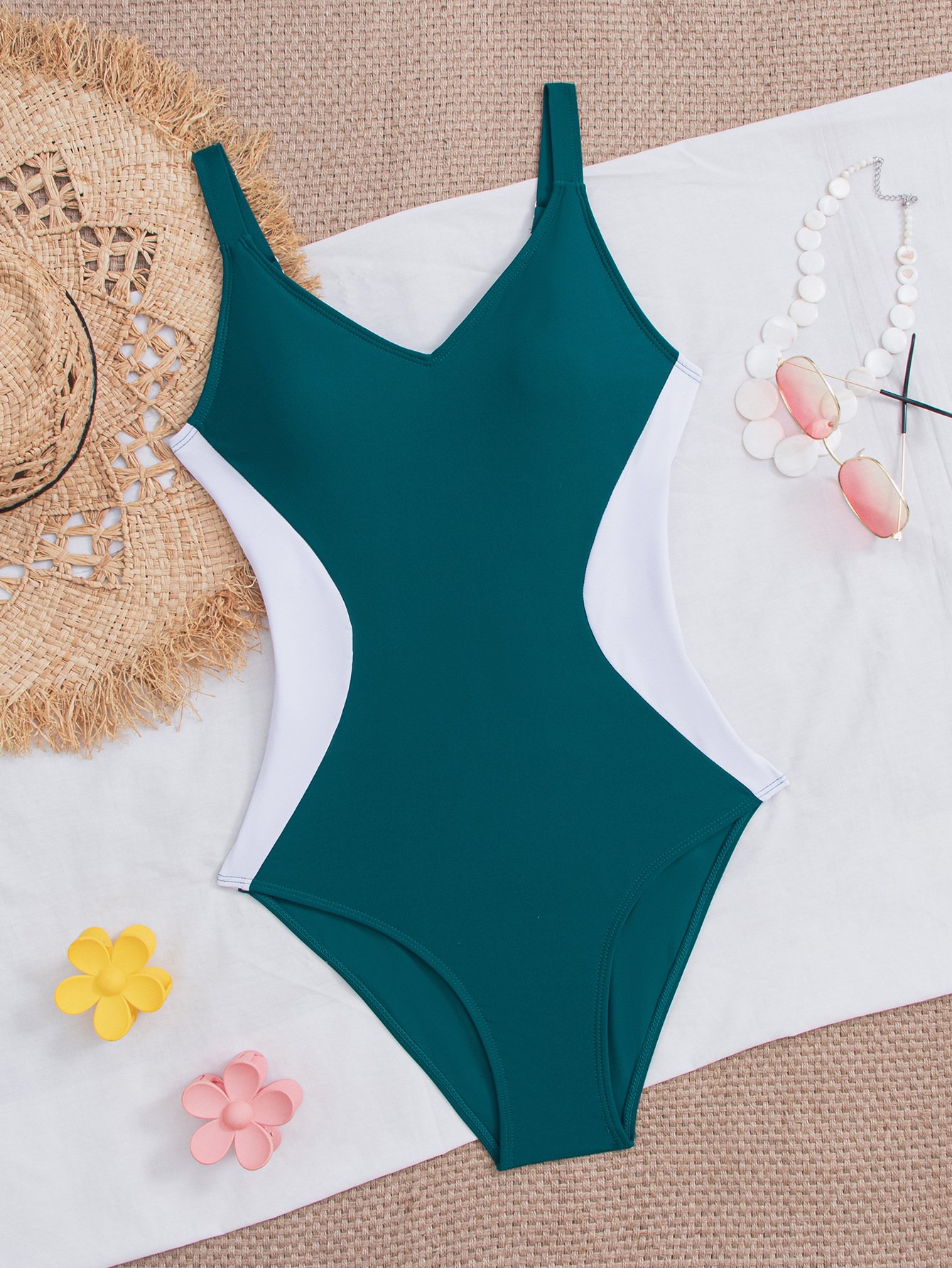 Teal and white colorblock one-piece swimsuit featuring a V-neckline and high-cut legs.