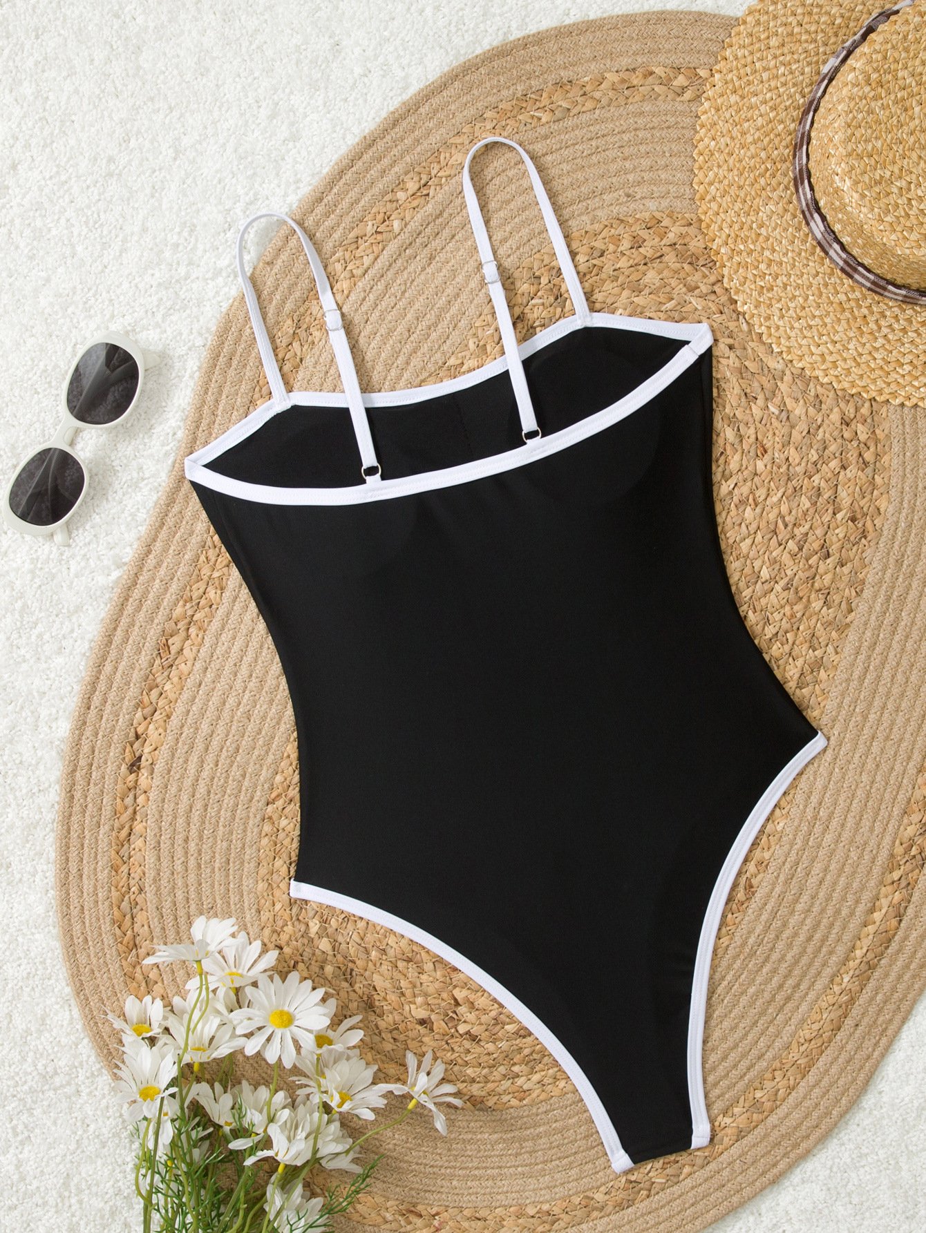 Black one-piece swimsuit featuring white piping, a square neckline, and thin adjustable straps.