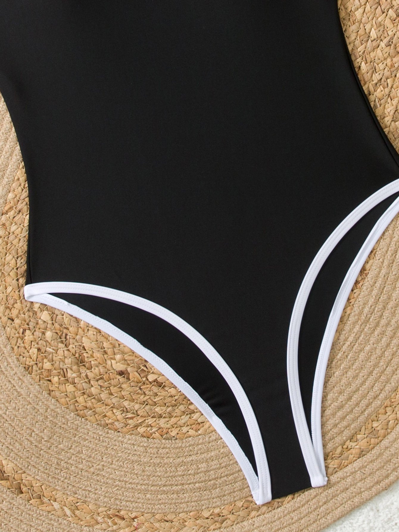 Black one-piece swimsuit featuring white piping along high-cut leg openings.