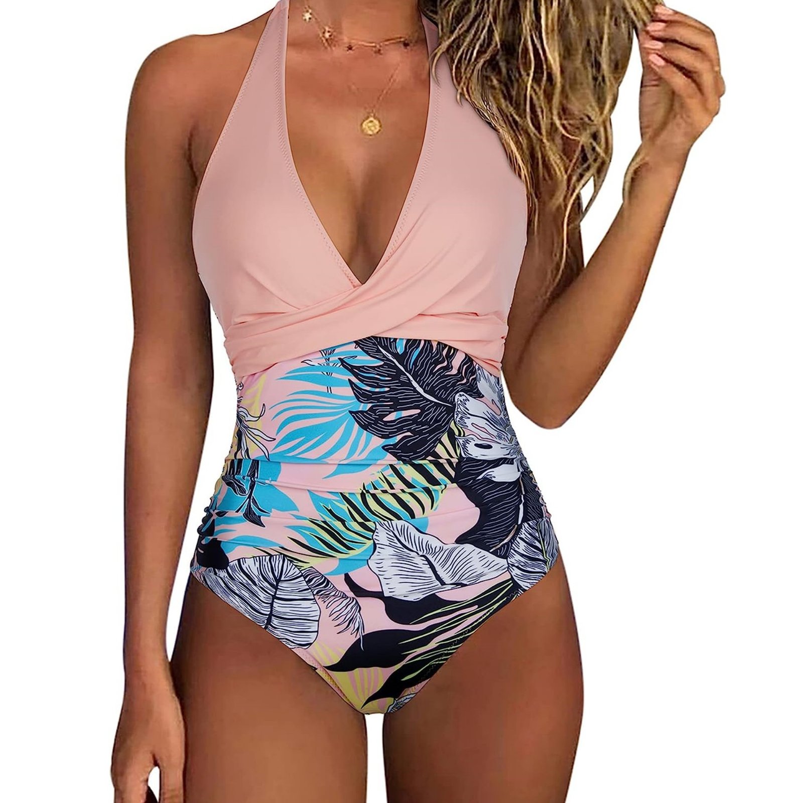 Pink halter one-piece swimsuit with a twist-front bodice and tropical leaf print high-waisted bottom.