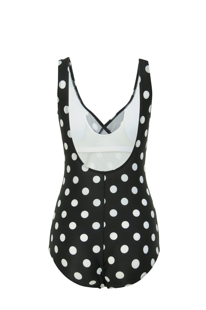 Black one-piece swimsuit with white polka dots, featuring wide shoulder straps, a deep V-back, and a classic leg