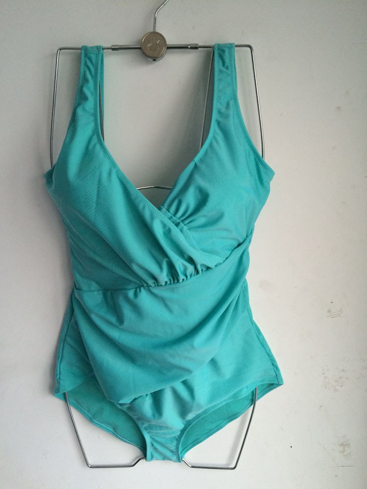 Teal one-piece swimsuit featuring a deep V-neckline, wrap-front bodice, and ruched waist detailing.