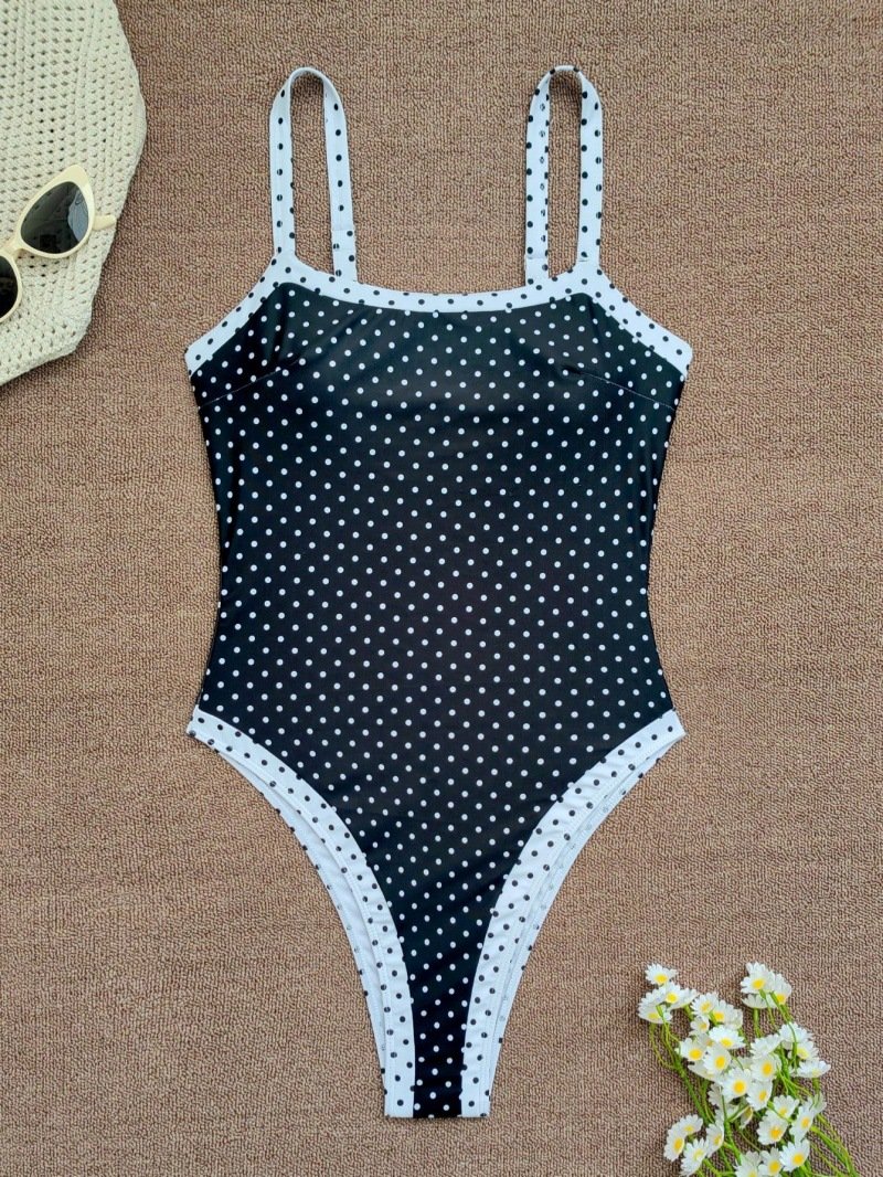 Black and white polka dot one-piece swimsuit with square neckline and contrasting trim.