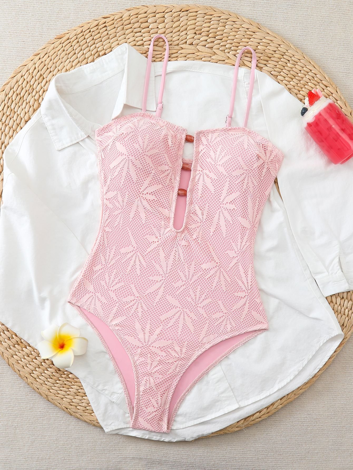Pink mesh one-piece swimsuit with adjustable straps, plunge neckline, and button closure.