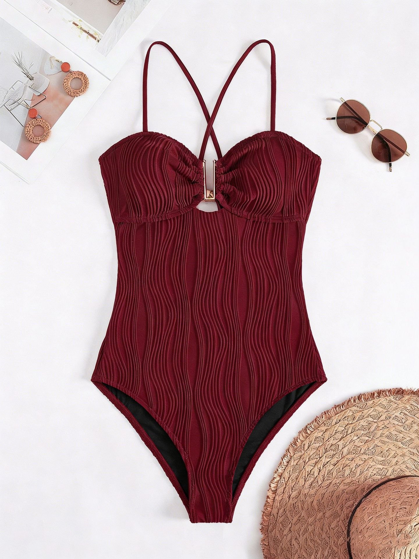Burgundy ribbed one-piece swimsuit featuring a plunging sweetheart neckline, central metal ring detail, and crisscross straps.