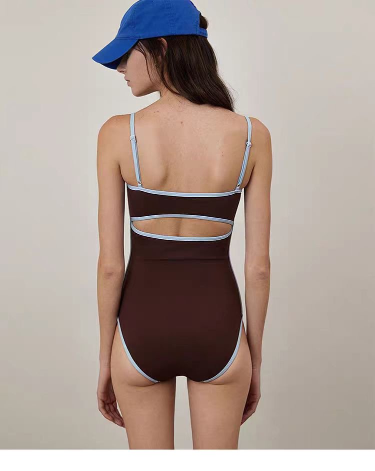 Brown one-piece swimsuit with light blue contrast piping, adjustable spaghetti straps, and a back cutout detail.