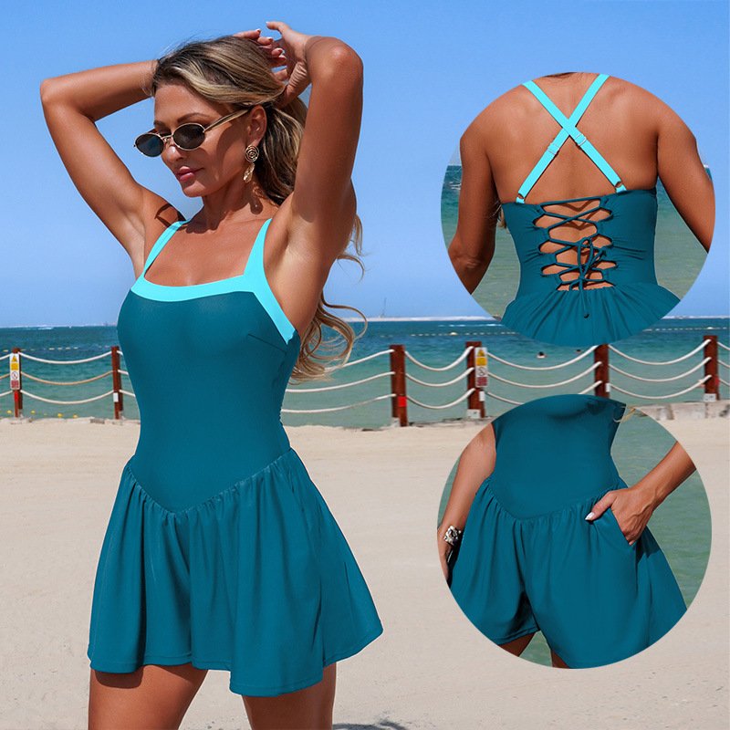Teal women's one-piece swimsuit with light blue contrast straps, square neckline, lace-up back, and flared skirted bottom with