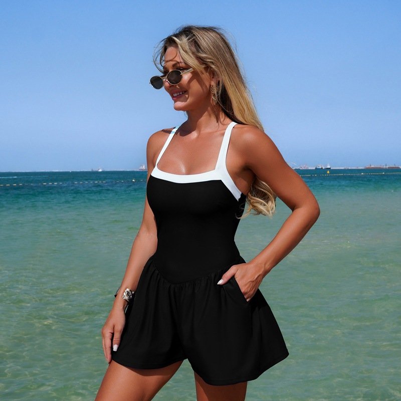 Black and white contrast strap square neck skirted one-piece swimsuit with side pockets.