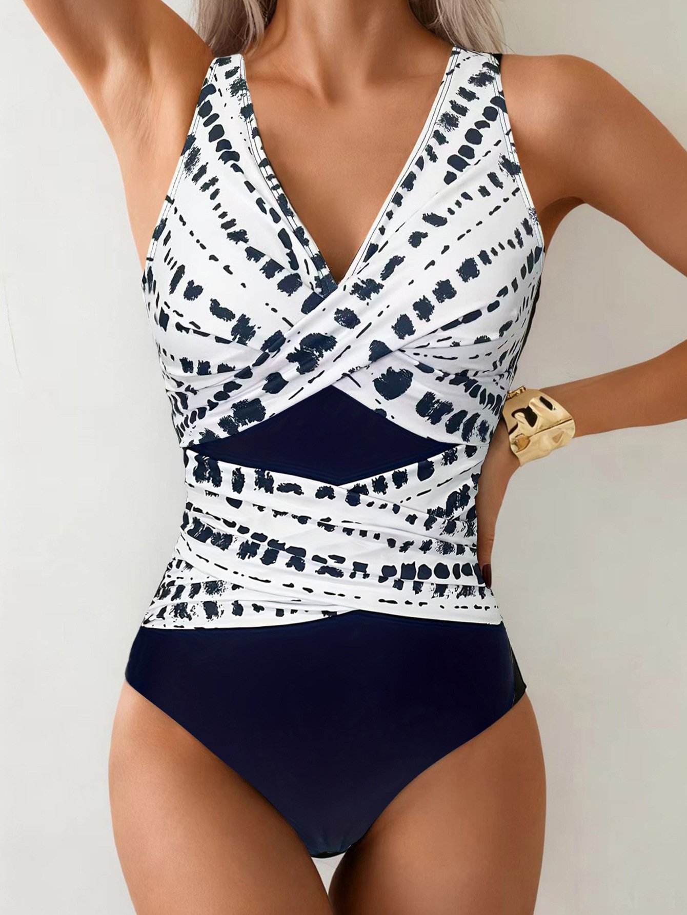 White and navy blue colorblock wrap-front halter one-piece swimsuit with deep V-neckline.
