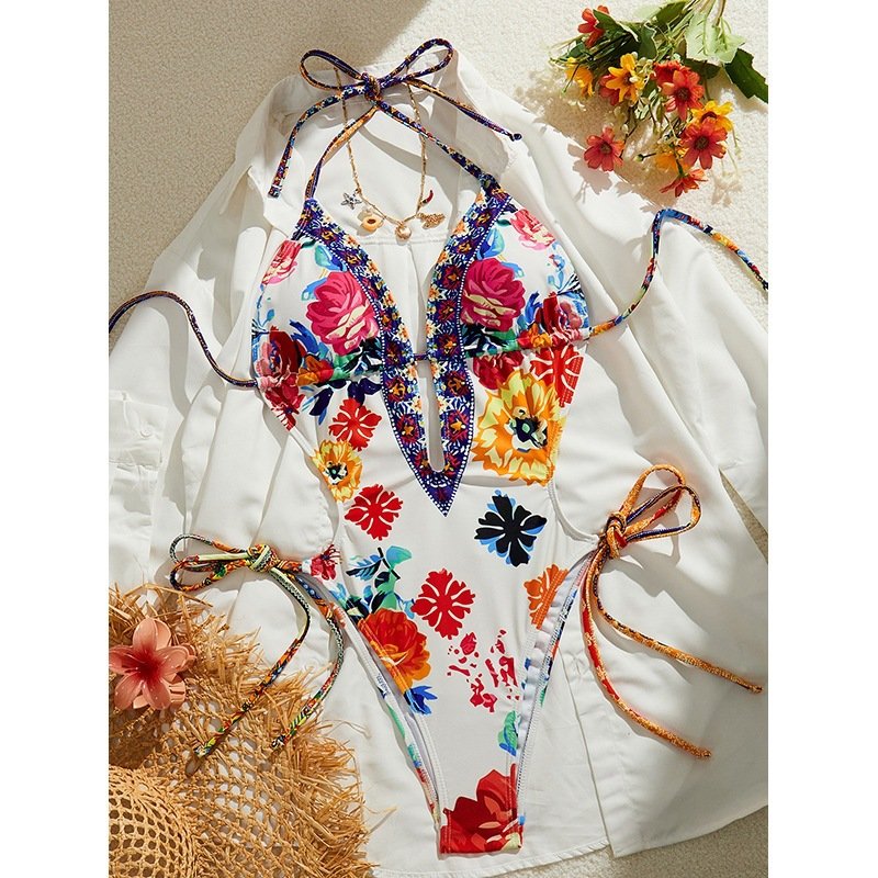 Floral print plunging halter one-piece swimsuit featuring side tie strings and a front keyhole cutout.