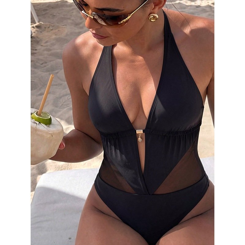 Black halter neck one-piece swimsuit with deep plunge front, sheer mesh midriff panel, and high-cut legs.