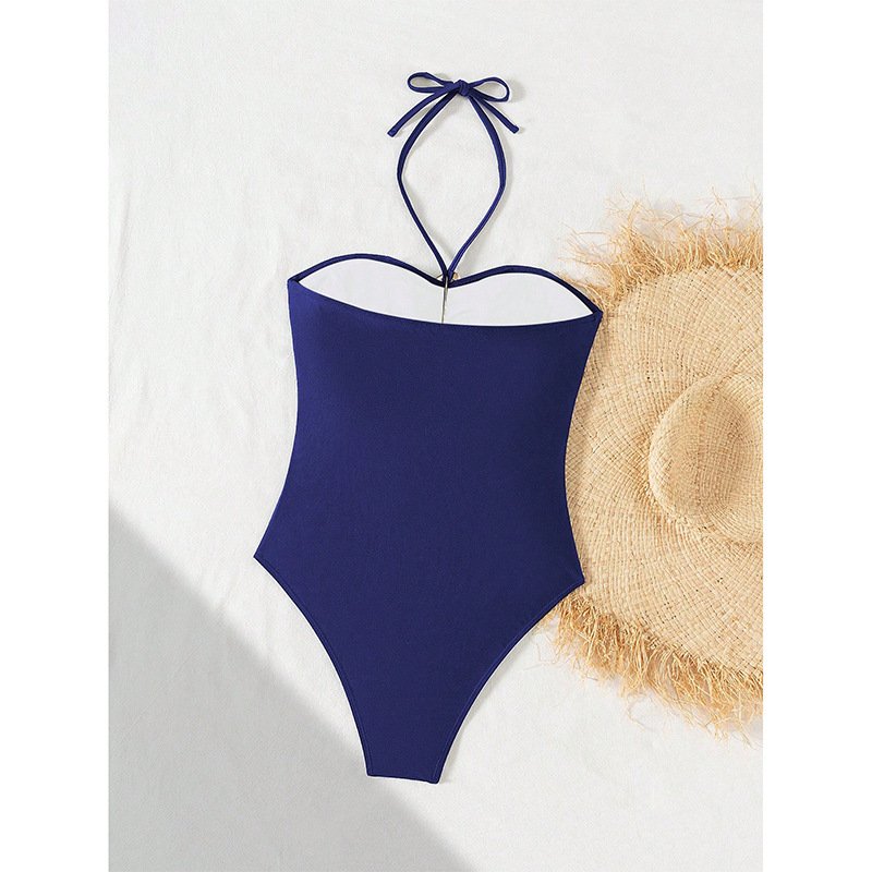 Navy blue halter neck one-piece swimsuit with front ring detail and high-cut legs.