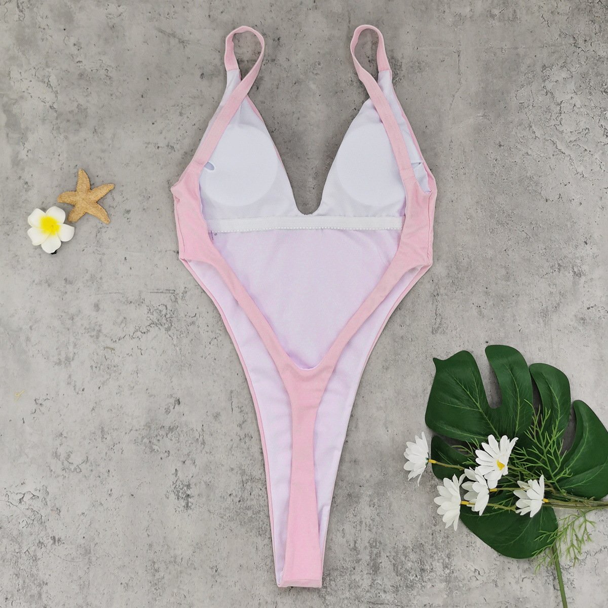 Pink and white one-piece swimsuit with a deep V-neckline, fixed straps, and high-cut legs.