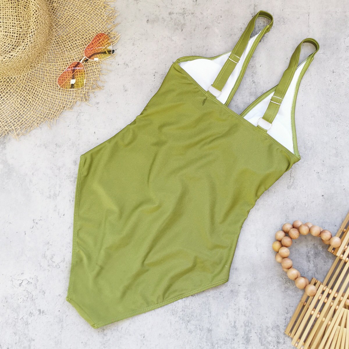 Olive green one-piece swimsuit with adjustable double straps and white lining.