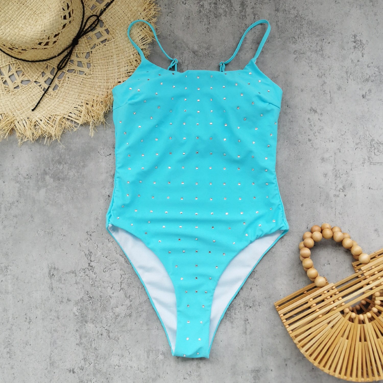 Blue rhinestone embellished one-piece swimsuit with adjustable spaghetti straps and high-cut legs.