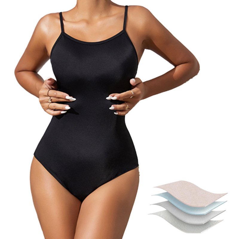 Black women's open-back one-piece swimsuit with thin straps and high-cut legs, featuring layered fabric detail.