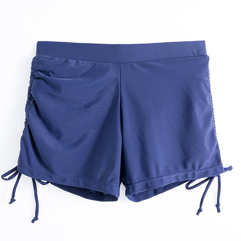 Navy blue high-waisted swim shorts featuring a wide elastic waistband and adjustable drawstring ties at the ruched sides.