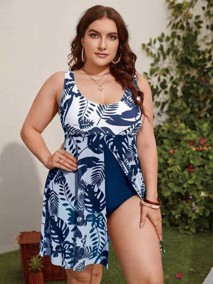 Blue and white leaf print tankini set with attached flowy skirt overlay and solid navy bottoms.