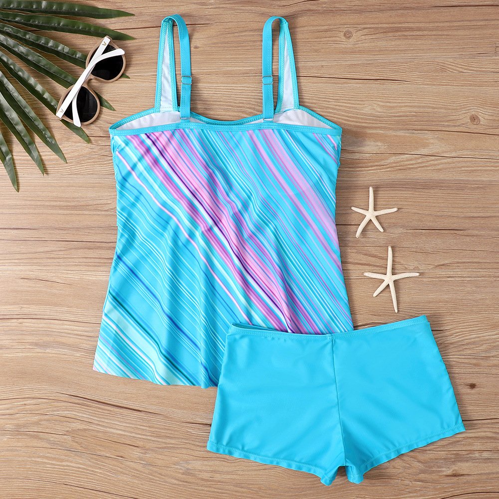 A plus-size tankini set featuring a blue and pink striped twist-front top with adjustable straps and matching solid