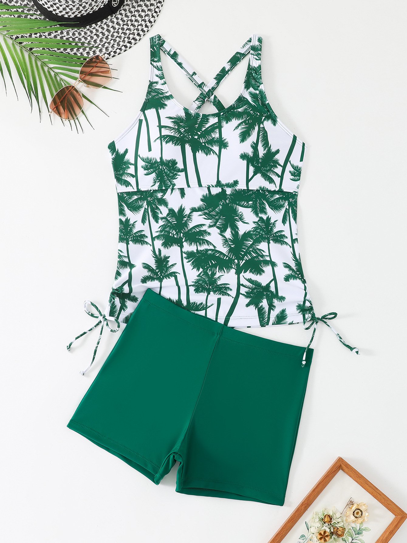 White and green palm tree print tankini top with crossback straps and side ties, paired with solid green